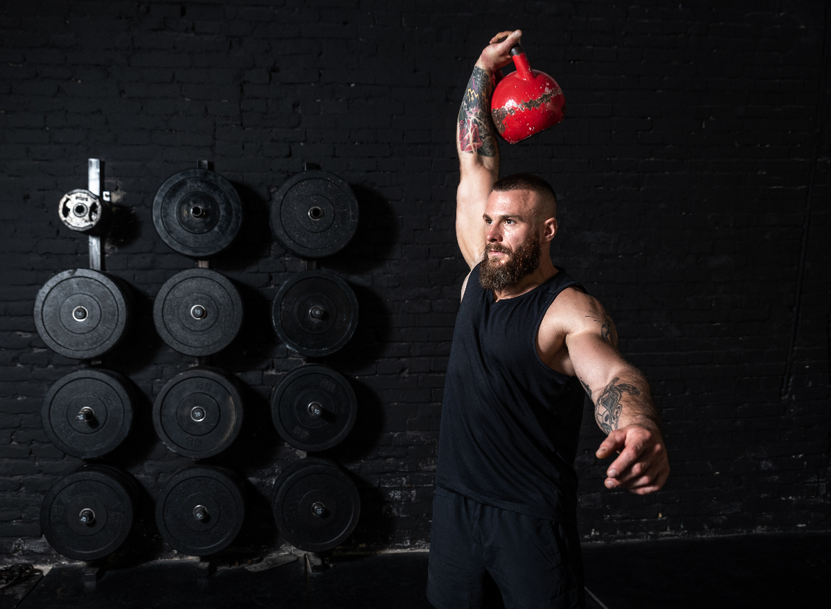 fit, muscular man doing kettlebell exercises to build size and strength
