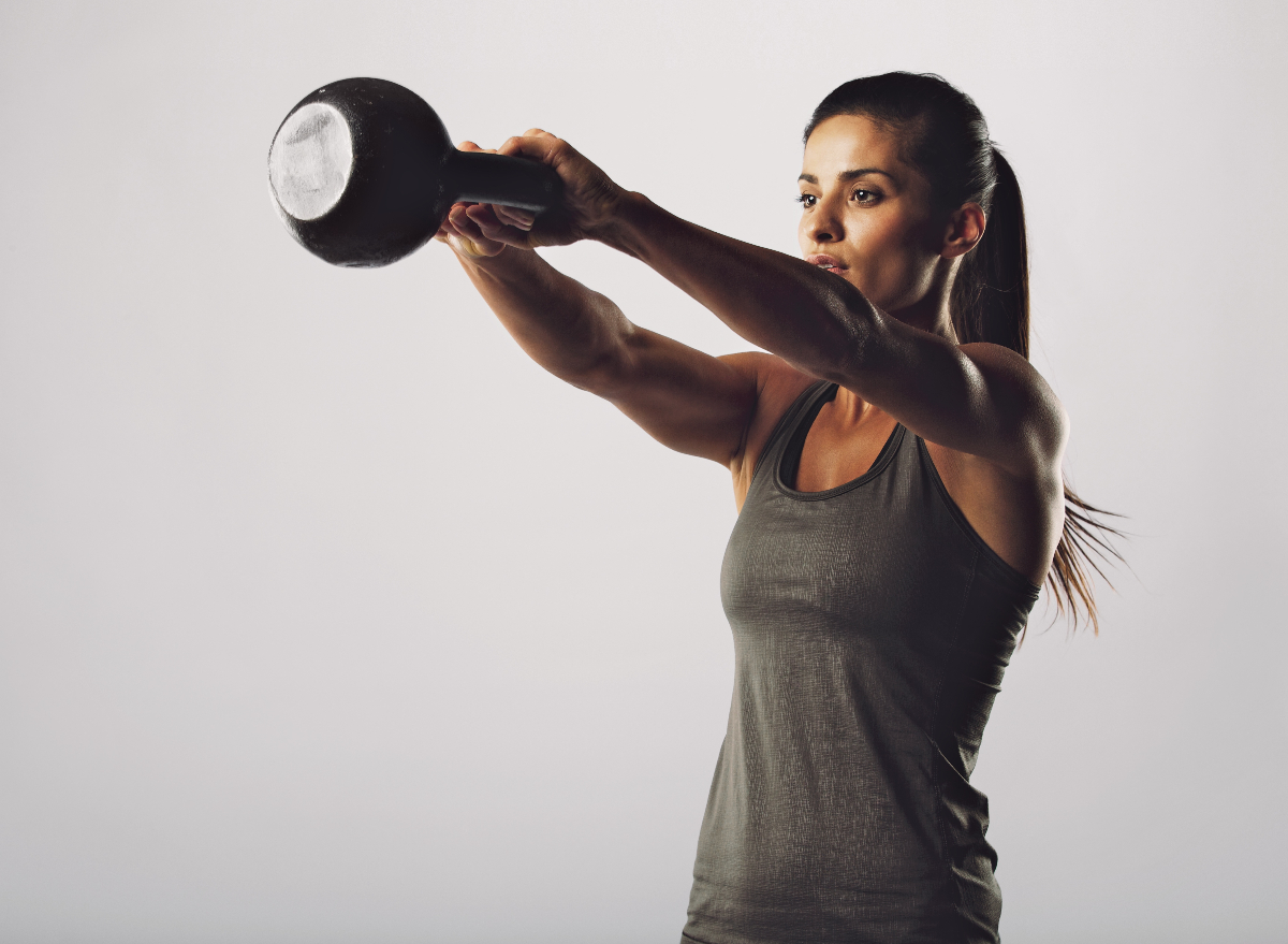 fit woman doing kettlebell swings exercise part of 10-minute daily workout to get in shape