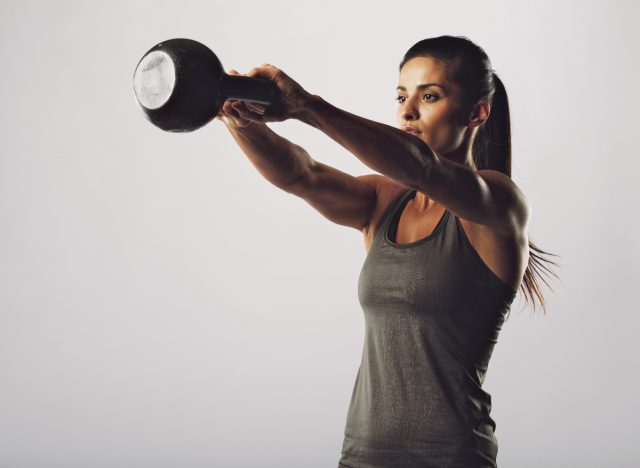 fit woman doing kettlebell swings exercise part of 10-minute daily workout to get in shape