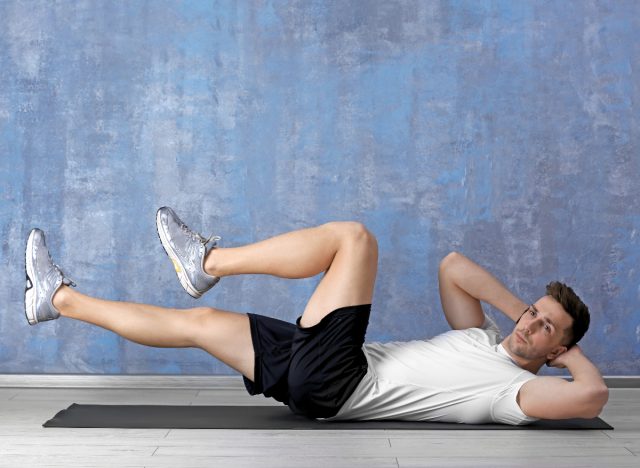 man doing bicycle crunches on workout mat to lose 10 pounds in a month