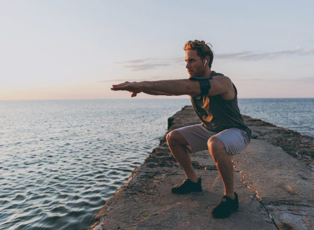 man squatting doing bodyweight exercises for stronger legs