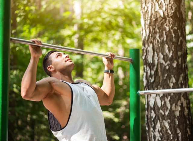 fit man doing pull-ups outdoors