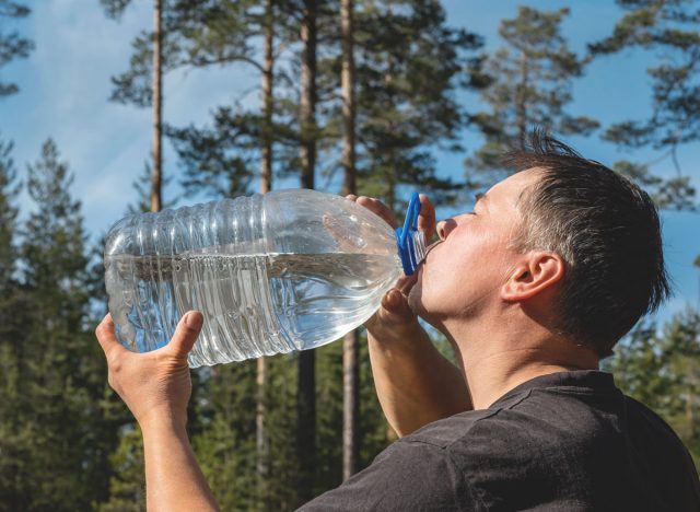 man drinking a gallon of water from a bottle