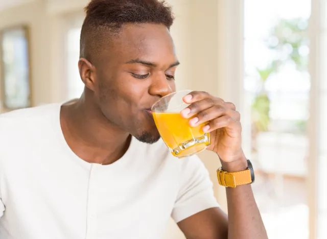 man drinking orange juice