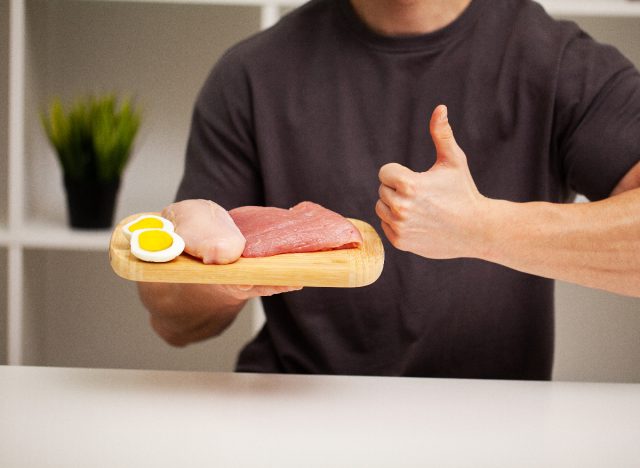 man holding plate of protein, concept of tips for men to lose belly fat