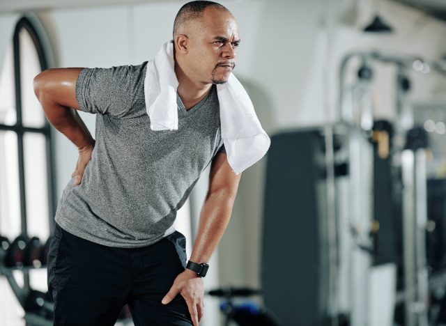 man dealing with lower back pain at gym, concept of exercises that destroy your back after 50