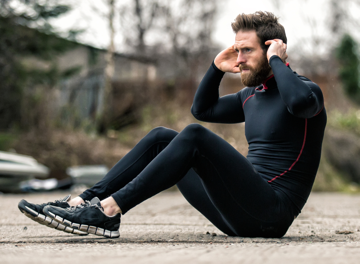man doing sit-ups outdoors, concept of popular exercises that destroy your body