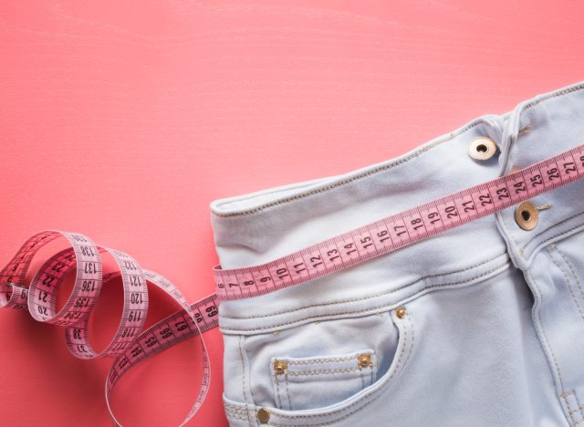 pink measuring tape and jeans, weight loss concept, how to get a flat belly after 50
