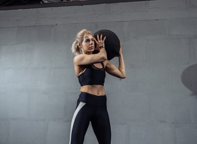 woman holding medicine ball, getting ready to perform a wood chopper