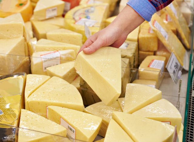Person choosing cheese at grocery store
