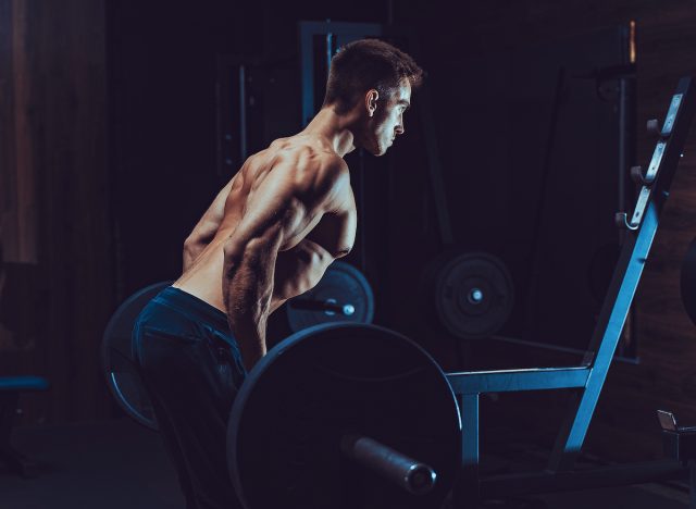 muscular man doing reverse grip barbell row