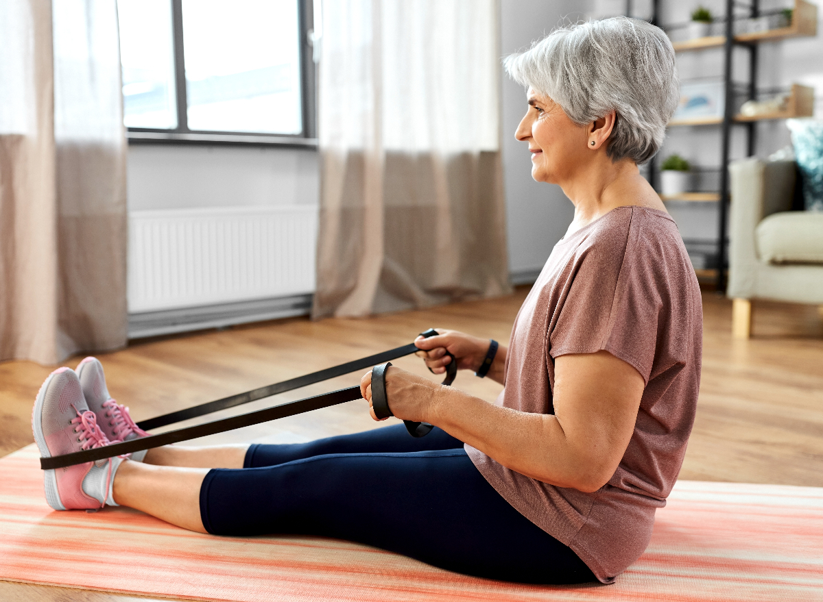 senior woman doing resistance band rows, concept of workout for seniors to rebuild strength
