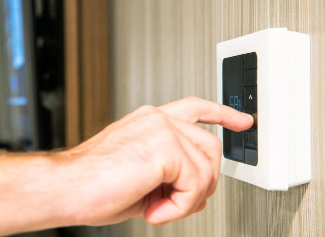 close-up of man's hand setting bedroom to cool temperature for sleep