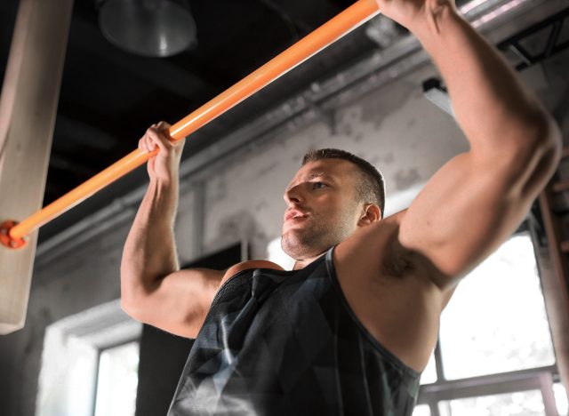 buff man doing wide-grip pull-ups