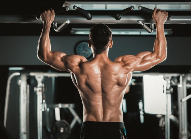 muscular man doing wide-grip pull-ups