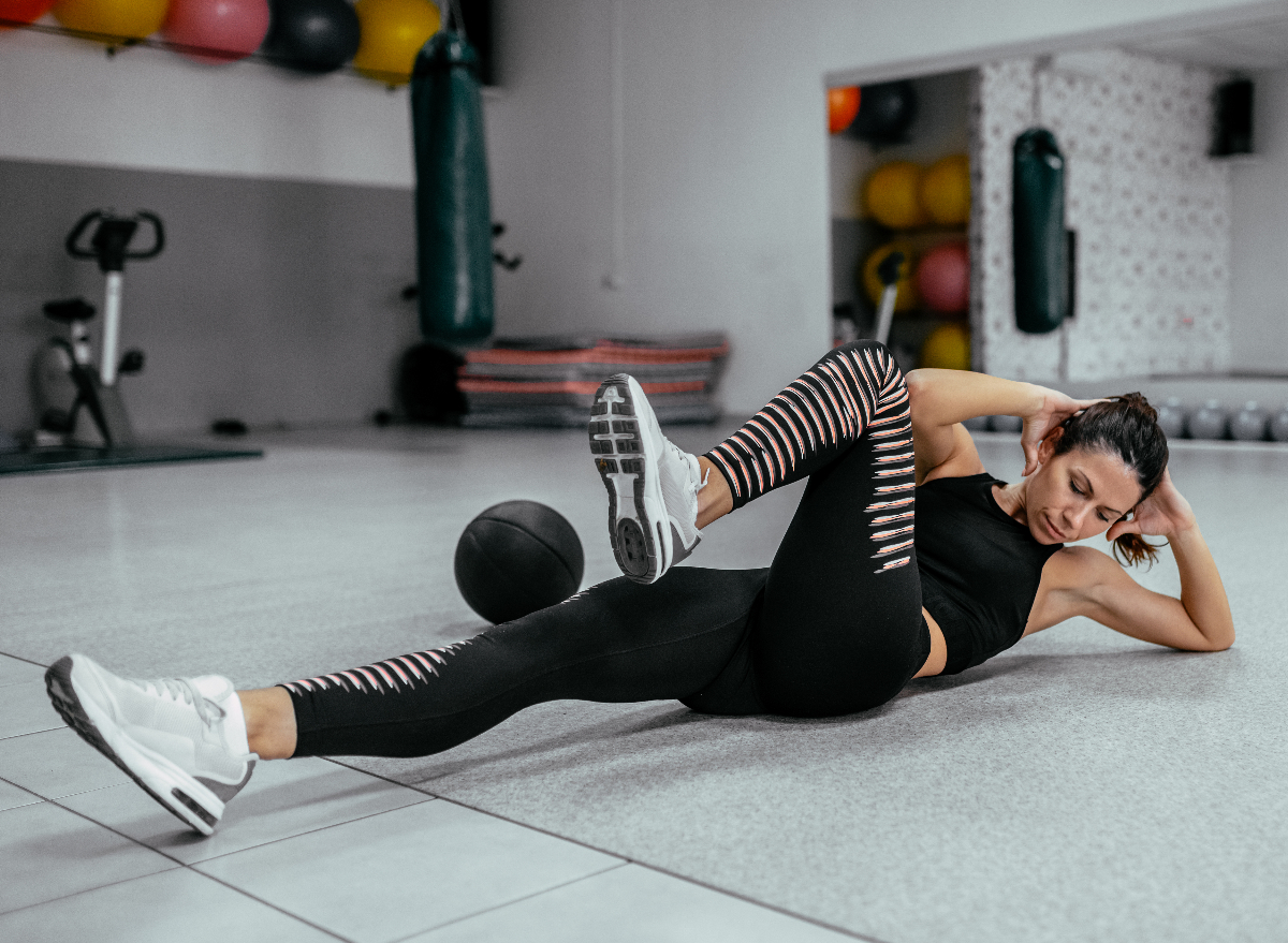 fit woman doing bicycle crunches, concept of exercises for women to keep belly fat off