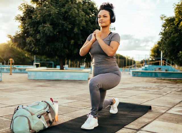 woman doing lunges in urban setting, demonstrating bodyweight workout to get rid of apron belly