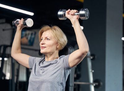 woman doing dumbbell strength exercises for saggy skin