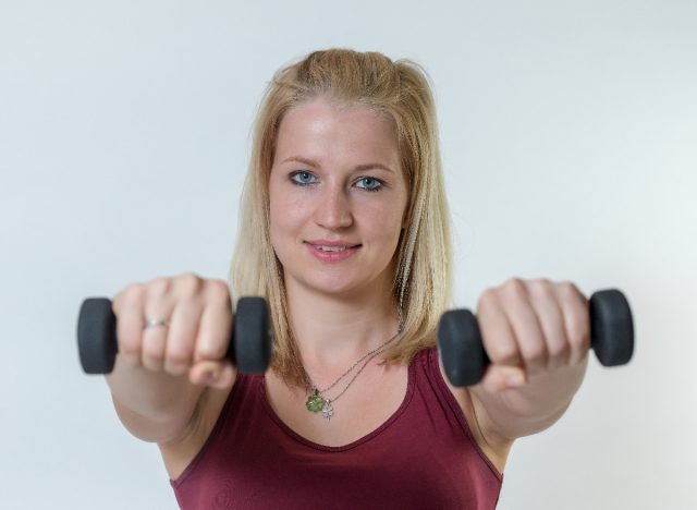 fitness woman holding out dumbbells