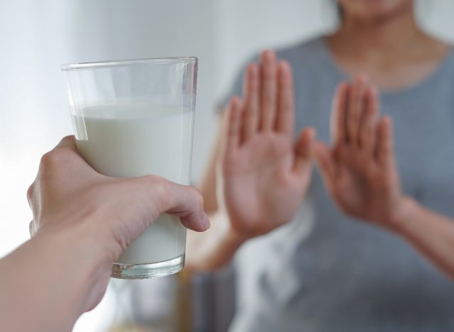 woman refuses glass of milk cutting back on dairy, concept of tips to lose 10 pounds quickly