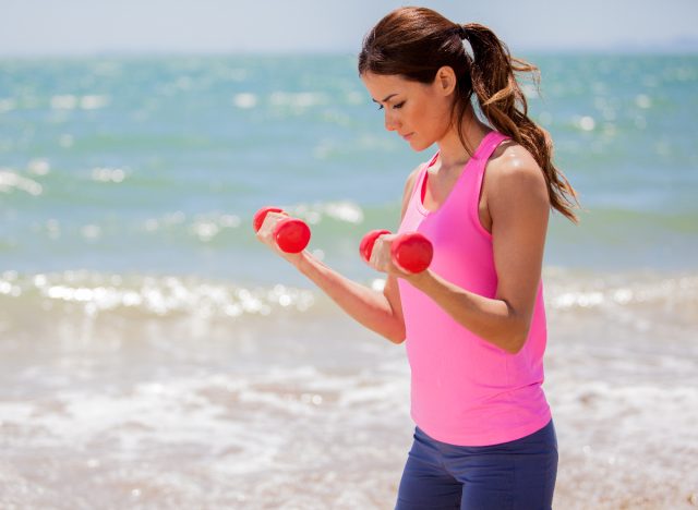 woman standing bicep curls, concept of strength exercises for a lean upper body