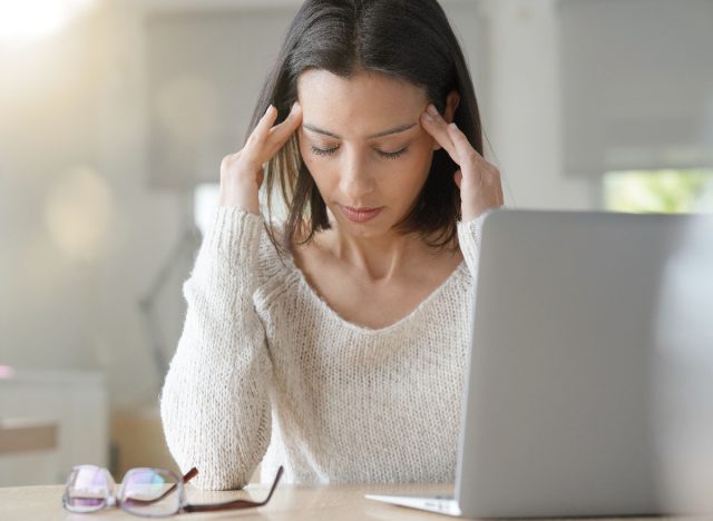 woman stressed at desk with laptop