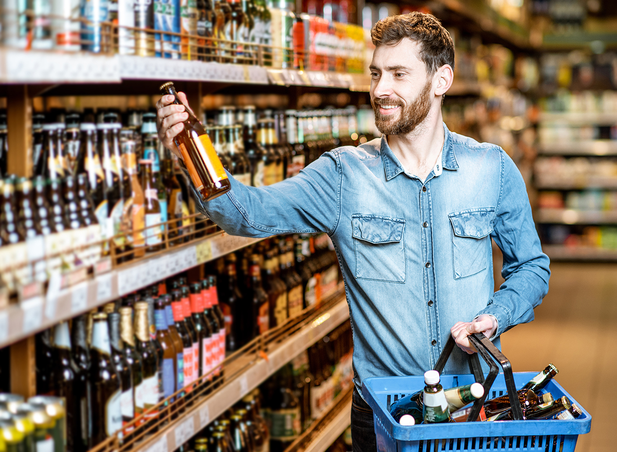 Man taking beer from the shelves in the supermarket