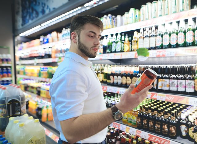 man chooses beer in a supermarket