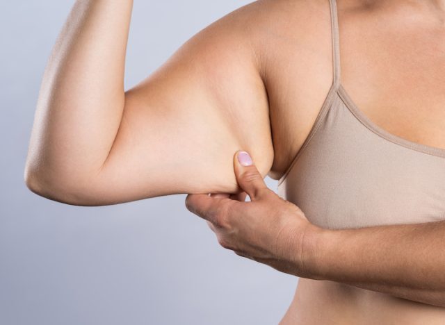 close-up woman holding onto arm fat