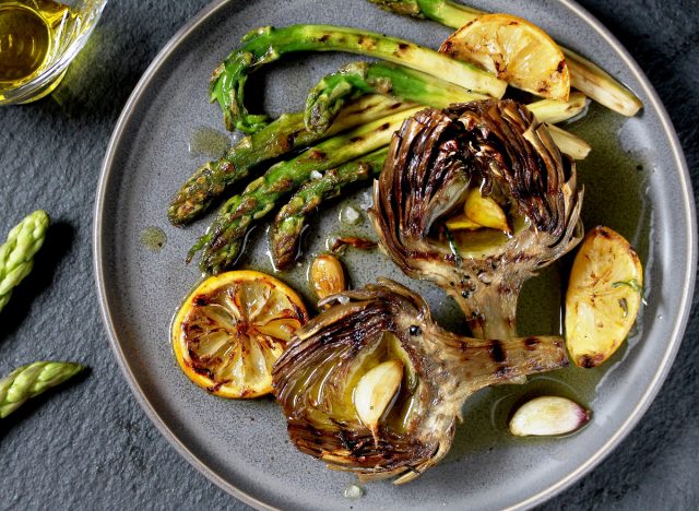 artichokes and asparagus on plate with lemon