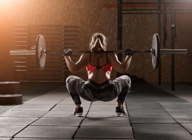 woman doing barbell squats