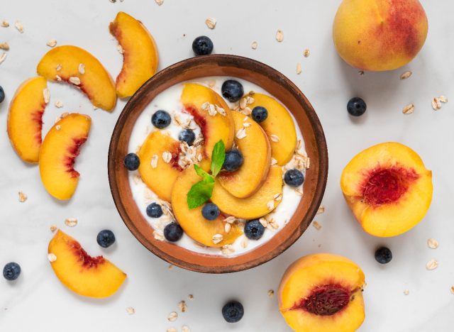 bowl of oats, yogurt, peaches, and blueberries