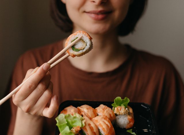 close-up of woman eating sushi, concept of surprising habits that cause rapid weight gain