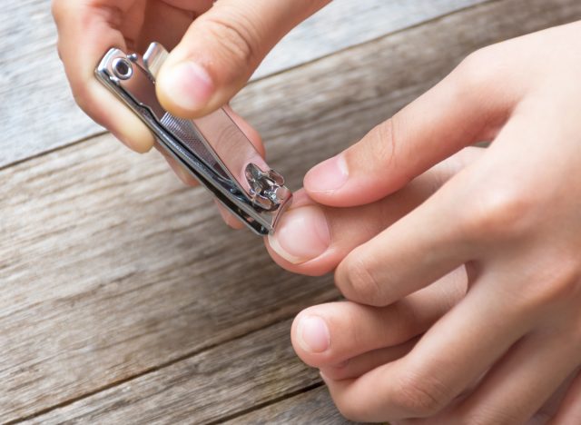 close-up cutting toenails too close, concept of daily habits that destroy feet