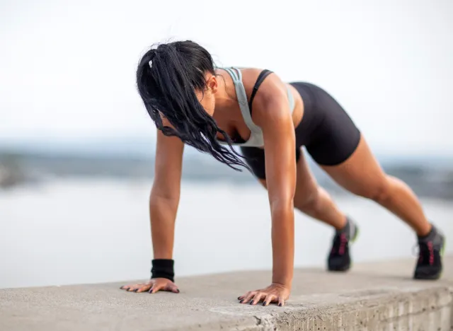 fit woman doing plank holds outdoors