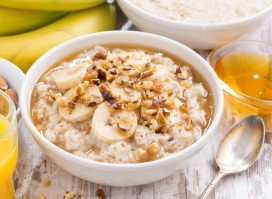 large bowl of oatmeal with bananas and honey, concept of surprising breakfast foods that can destroy your waistline
