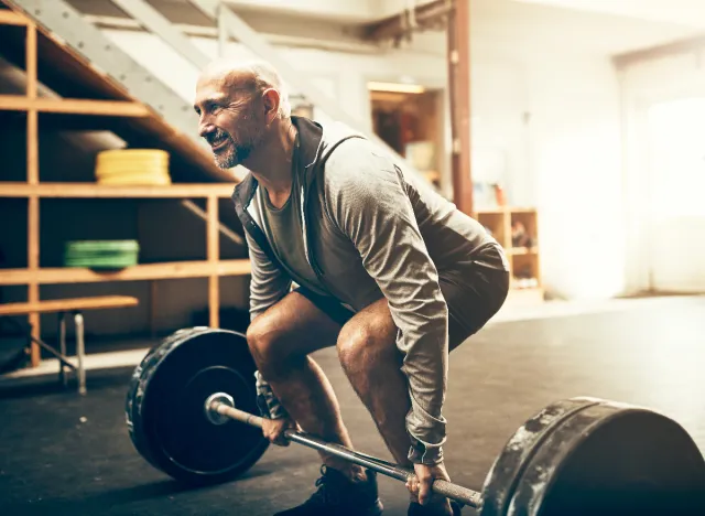 mature man doing barbell deadlifts, concept of strength exercises for men in their 60s