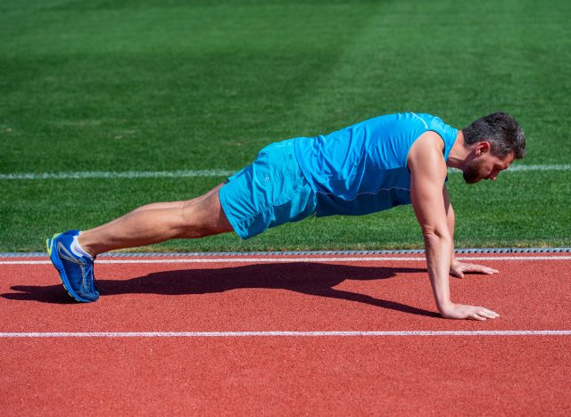 man doing pushups on track