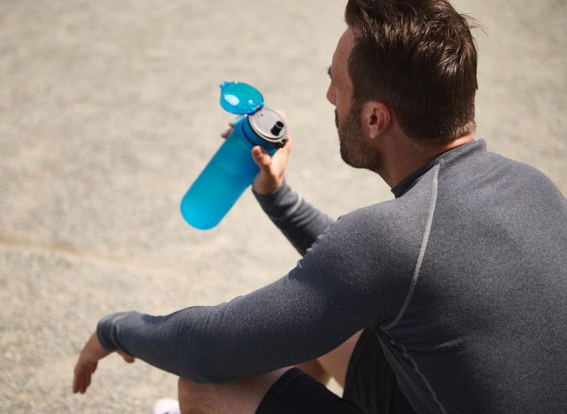 middle-aged man drinking water before workout