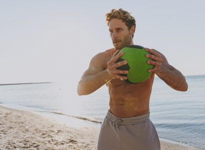 man holding medicine ball doing exercises to burn belly fat
