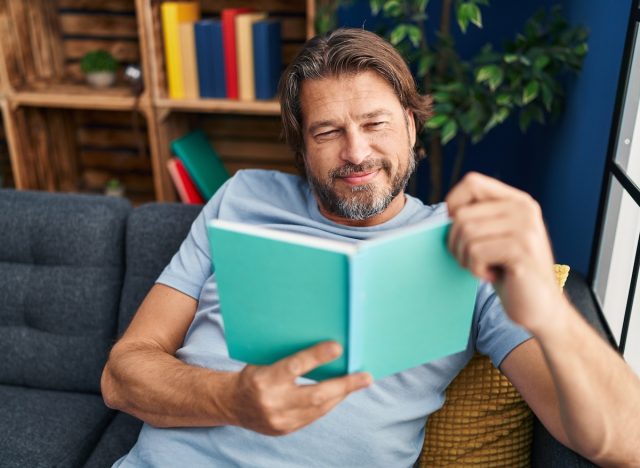 middle-aged man reading on couch