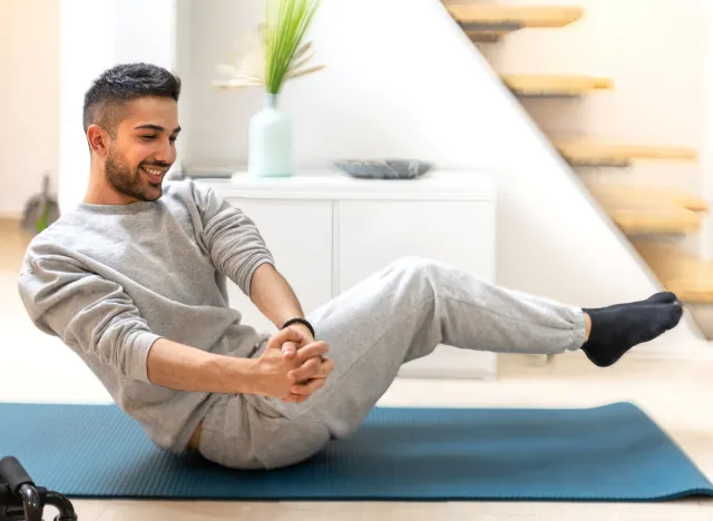 man doing Russian twists exercise at home