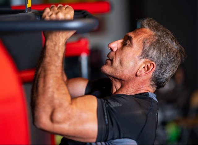 mature man doing pull-ups, concept of exercises that are too hard on your arms after 50