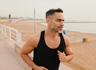 mature man running outdoors by the beach, concept of weekly workout routine for men to do in their 50s