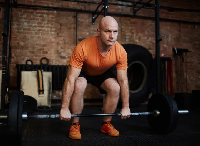 middle-aged man doing barbell deadlifts