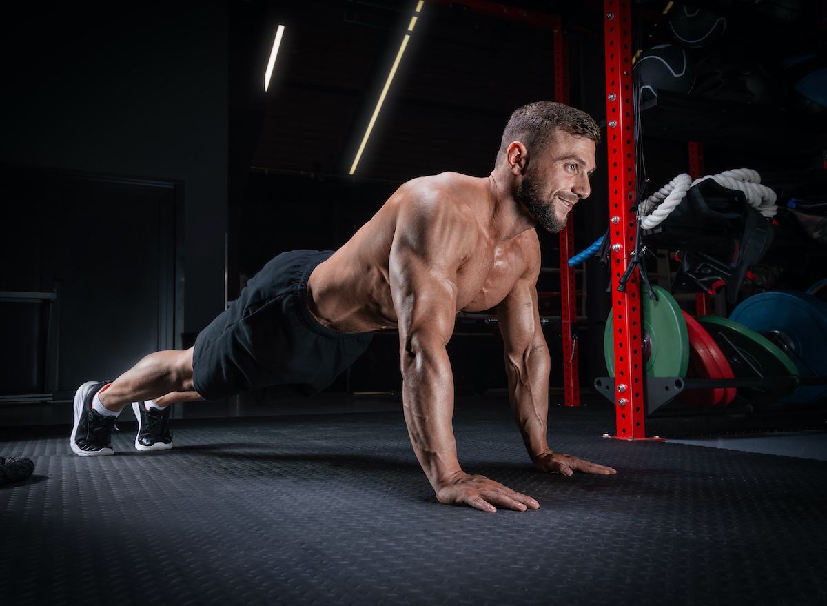 muscular man doing pushups, concept of workout for tapered waist