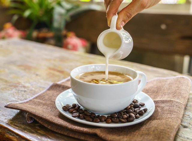 pouring creamer into coffee