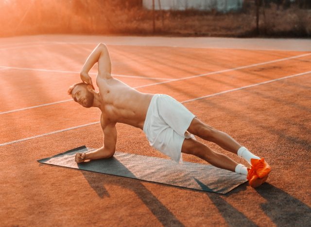 man doing side planks on court, concept of no-equipment exercises for men