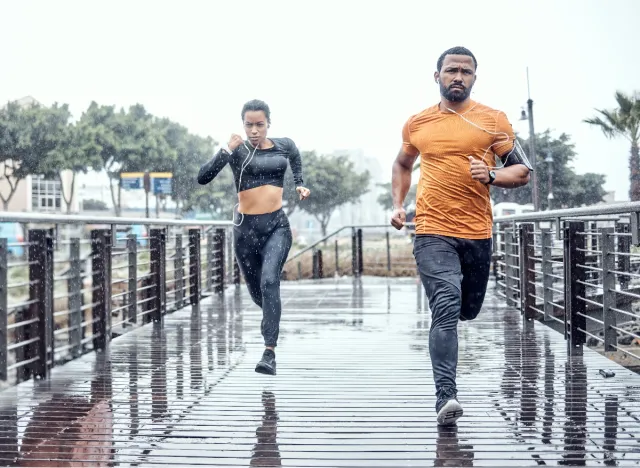 fit individuals sprinting in the rain