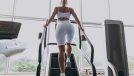 fitness woman doing StairMaster workout at gym, back view